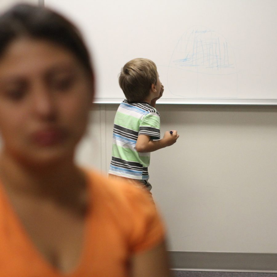 FILE - In this Sept. 10, 2014, file photo, an unidentified immigrant from Guatemala who declined to give her name, is interviewed, while her son paints on a whiteboard at the Artesia Family Residential Center, a federal detention facility for undocumented immigrant mothers and children in Artesia, N.M. The facility is now releasing more detainees rather than deporting them, according to Artesia Mayor Phillip Burch. (AP Photo/Juan Carlos Llorca, File)