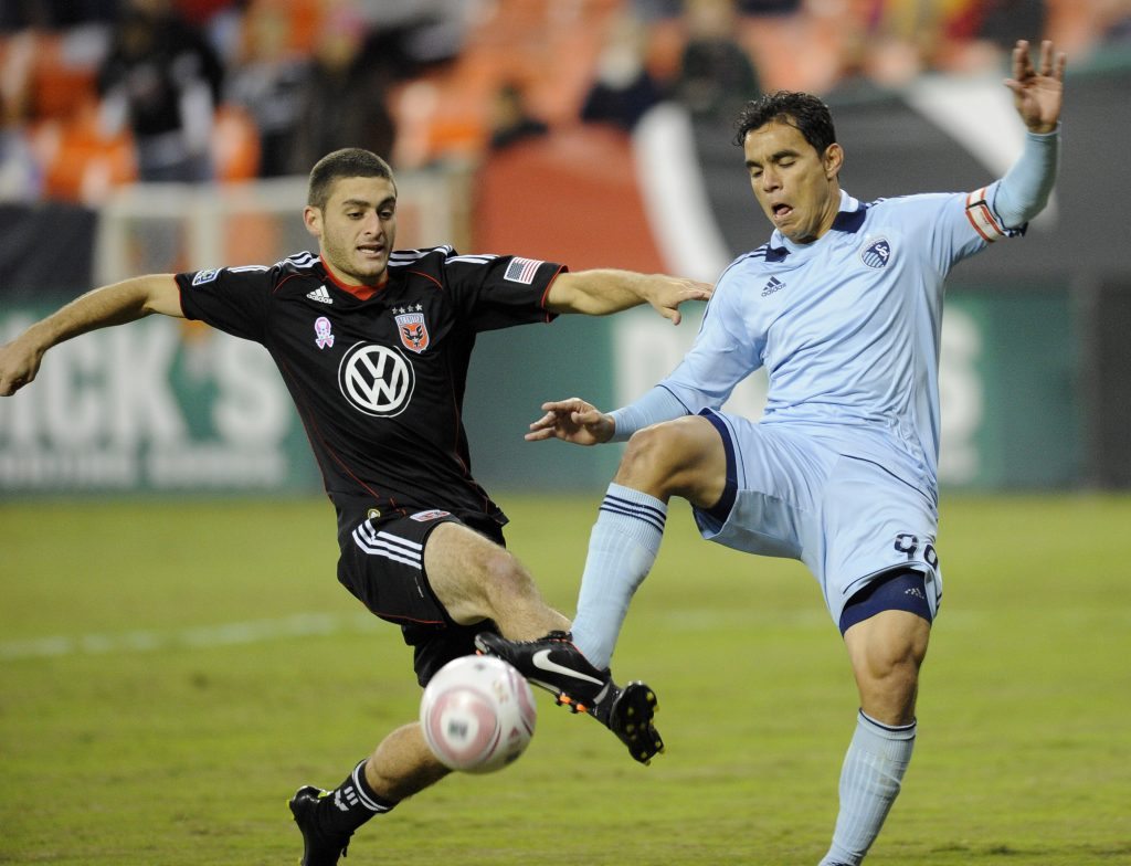 D.C. United defender Chris Korb, left, battles for the ball against Sporting Kansas City's Omar Bravo, right, during the first half of an MLS soccer game, Saturday, Oct. 22, in Washington. (AP Photo/Nick Wass)