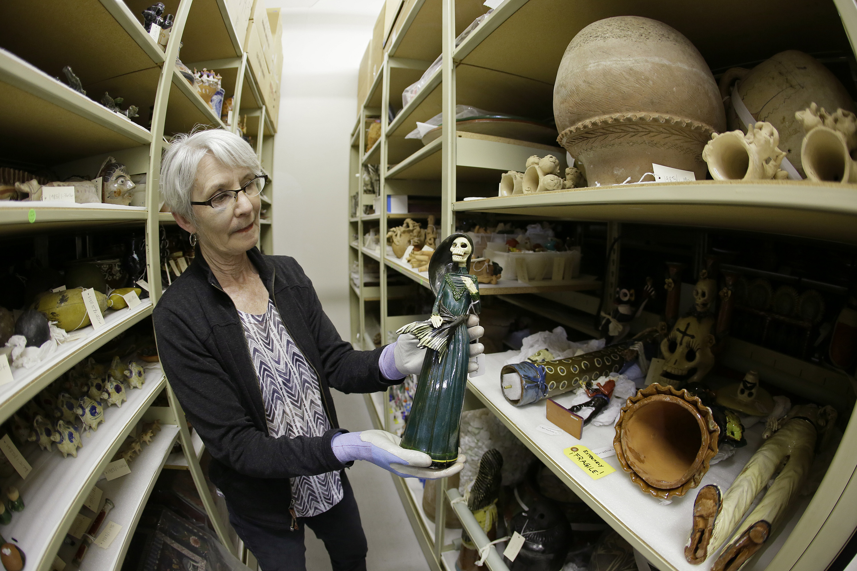 Mexican Museum In this photo taken Monday, June 27, 2016, registrar Wendy Niles holds a Day of the Dead sculpture "La Soldadera" by Alvaro de la Cruz being stored in a vault at the Mexican Museum currently located at Fort Mason in San Francisco. Construction of a four-story, state-of-the-art Mexican Museum is underway, realizing the dream of a late Mexican-American artist who four decades ago opened the city's first museum for Latino art in a Mission District storefront. The 60-000 square feet building in downtown San Francisco will be home to 16,000 pre-Columbian, colonial, modern and contemporary works of Mexican, Mexican-American and Latino art, the largest such collection in the country. (AP Photo/Eric Risberg)