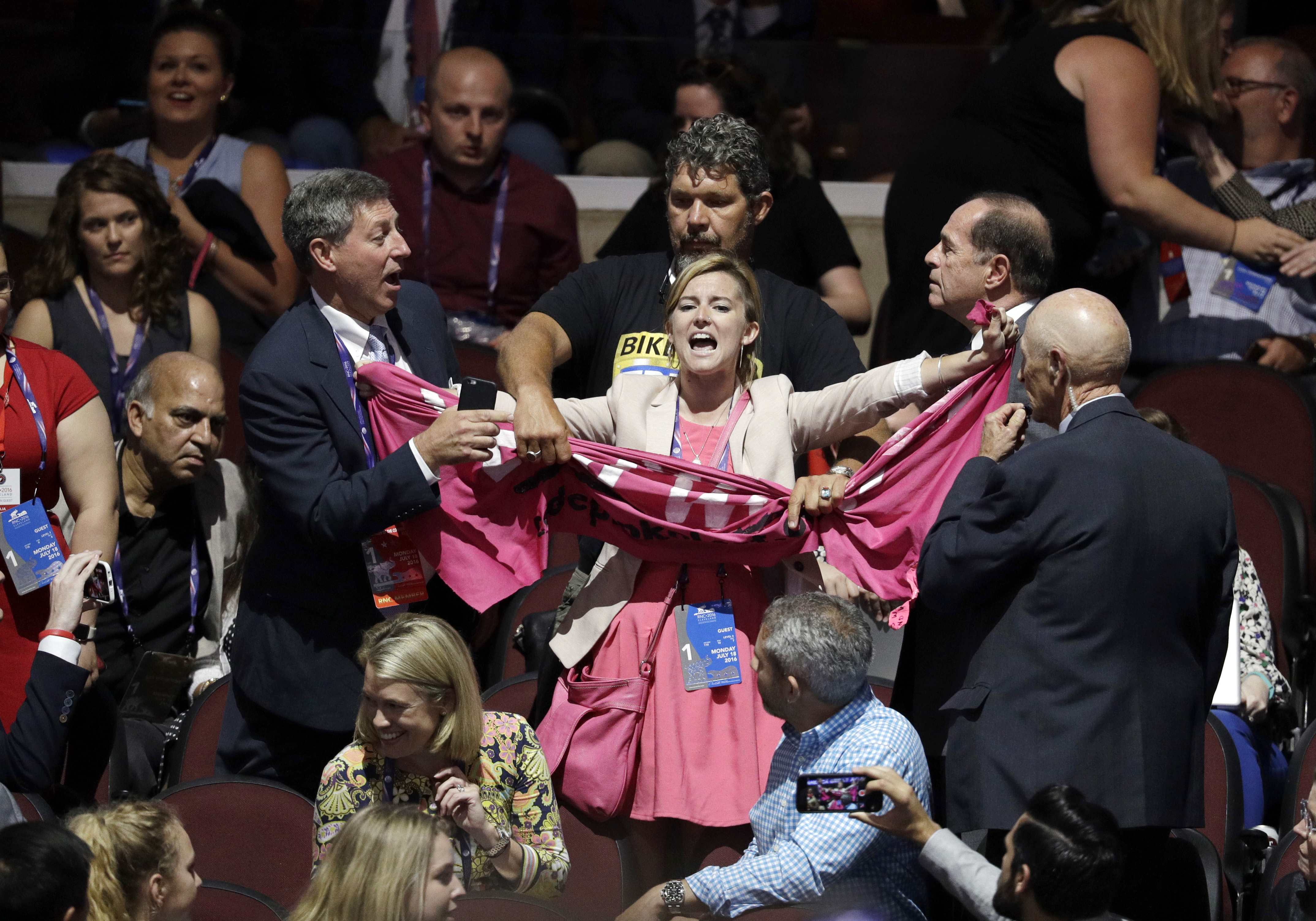 A protester scuffles with others delegates during first day of the Republican National Convention in Cleveland, Monday, July 18, 2016. (AP Photo/John Locher)
