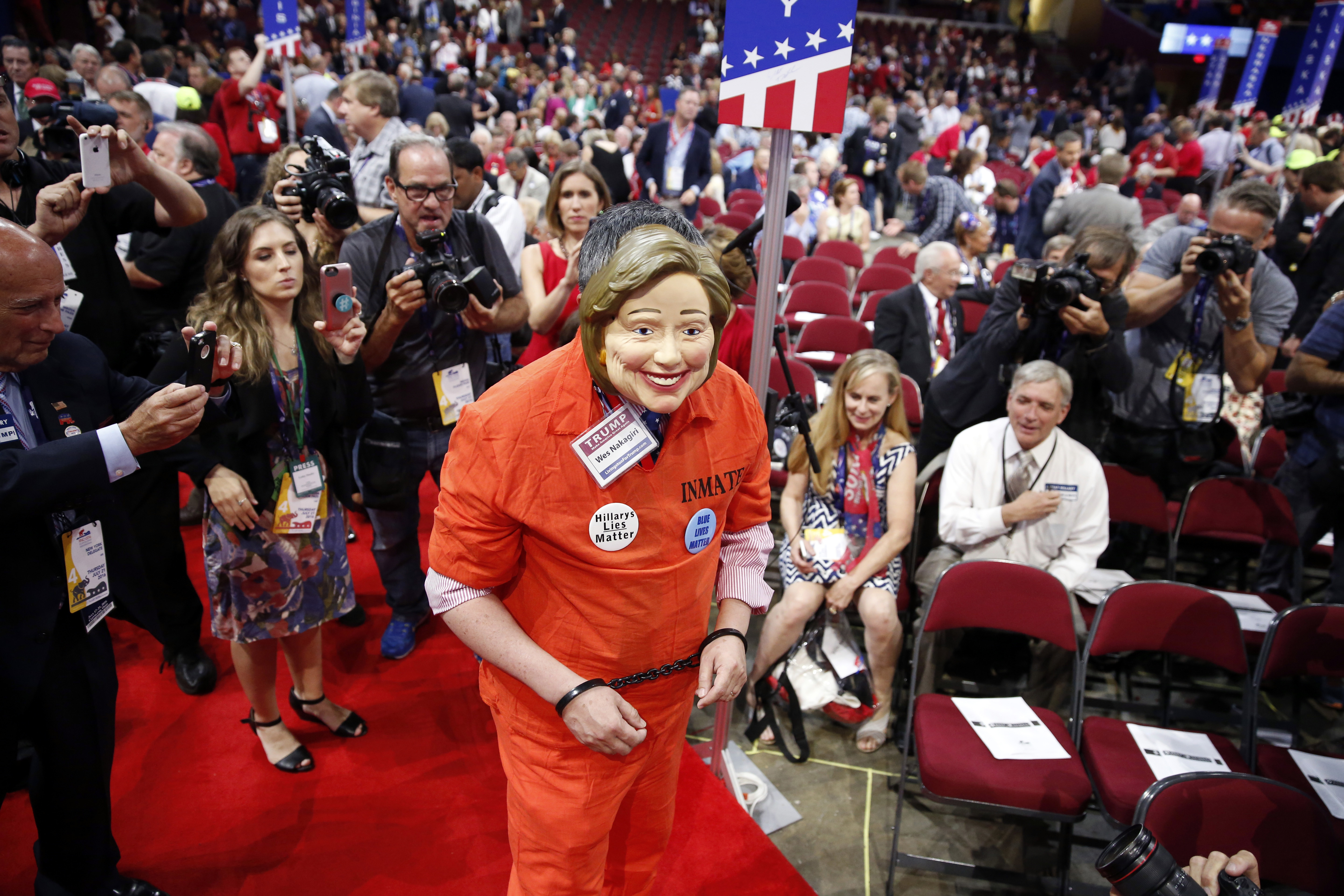 Michigan delegate Wes Nakagiri walks around in a jumpsuit with a Hillary Clinton mask before the final day of the Republican National Convention in Cleveland, Thursday, July 21, 2016. (AP Photo/Matt Rourke)