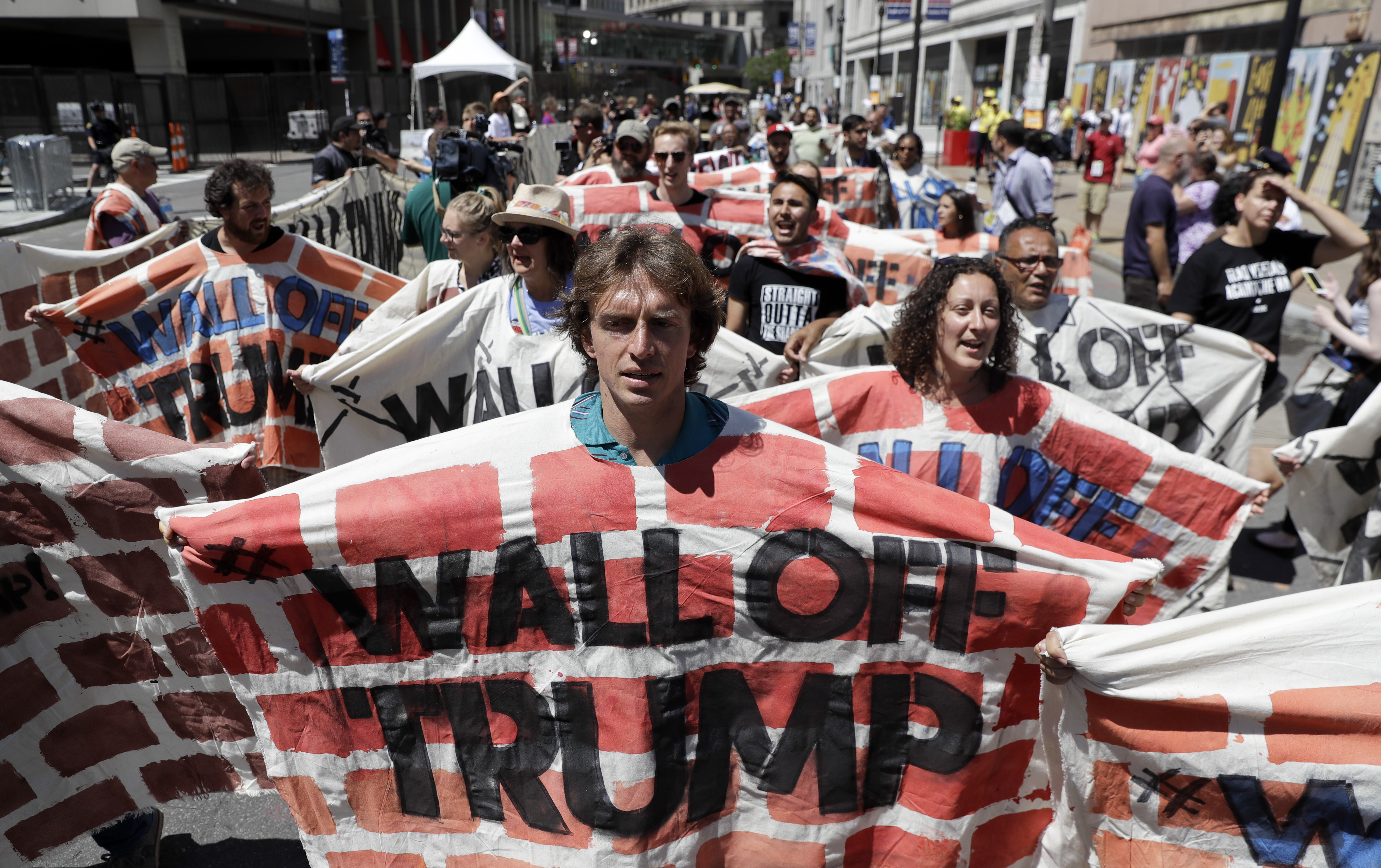Immigrant rights activists hold up a fabric wall protesting Republican presidential candidate Donald Trump, Wednesday, July 20, 2016, in Cleveland, during the third day of the Republican convention. (AP Photo/Patrick Semansky)