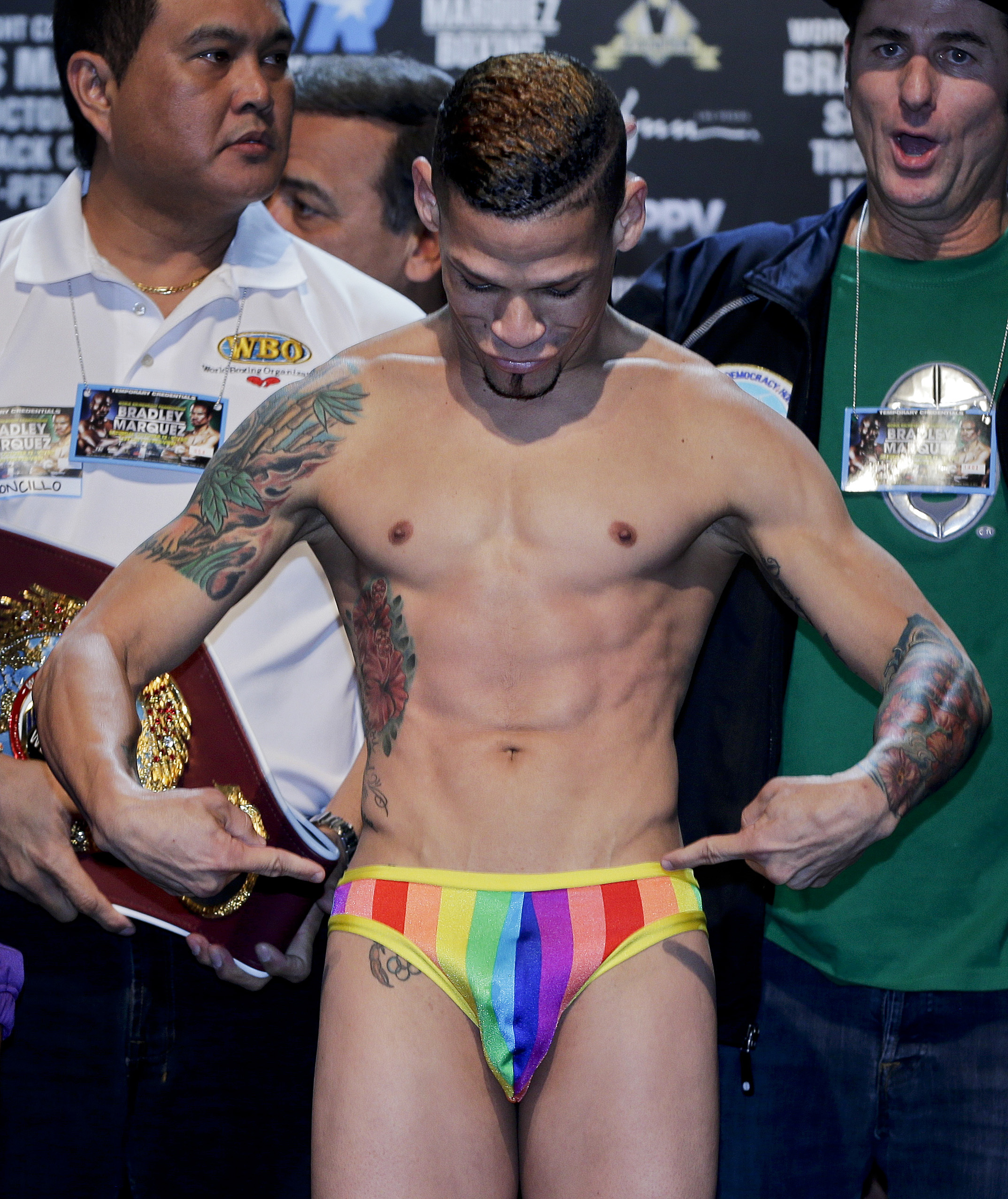 Orlando Cruz points to his rainbow colored briefs while standing on the scale during the weigh-in for the WBO featherweight title fight against Orlando Salido, Friday, Oct. 11, 2013, in Las Vegas. Cruz, boxing's first openly gay fighter, will take on Salido in the 12-round title fight on Saturday. (AP Photo/Julie Jacobson)