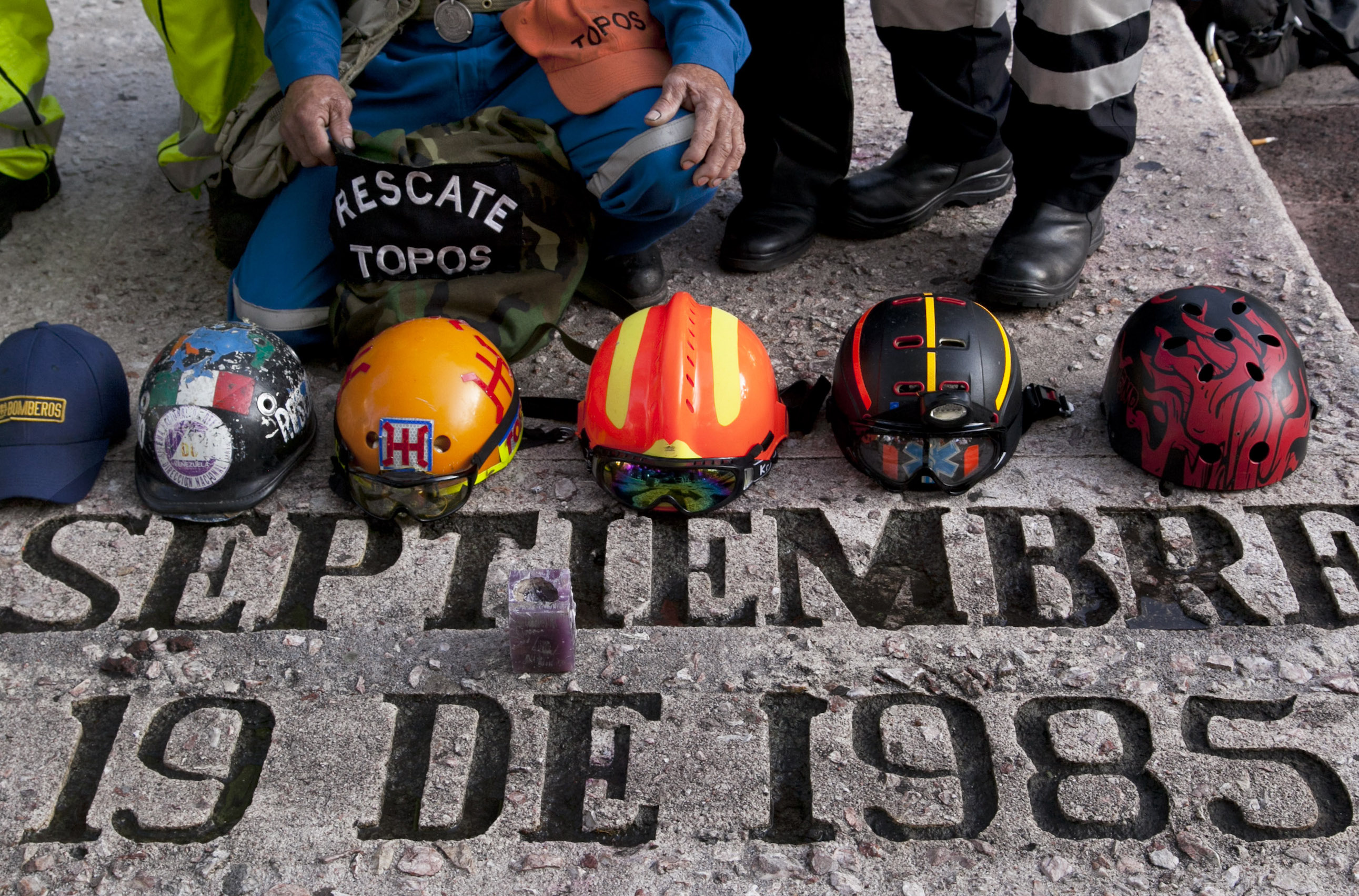 Rescue workers' hats sit on a memorial honoring those who died in the 1985 earthquake on the 30th anniversary in Mexico City, Saturday, Sept. 19, 2015. Voluntary civil brigades were created to lead rescue operations after the 8.1-magnitude earthquake struck Mexico City, killing thousands of people and leaving many homeless. (AP Photo/Marco Ugarte)