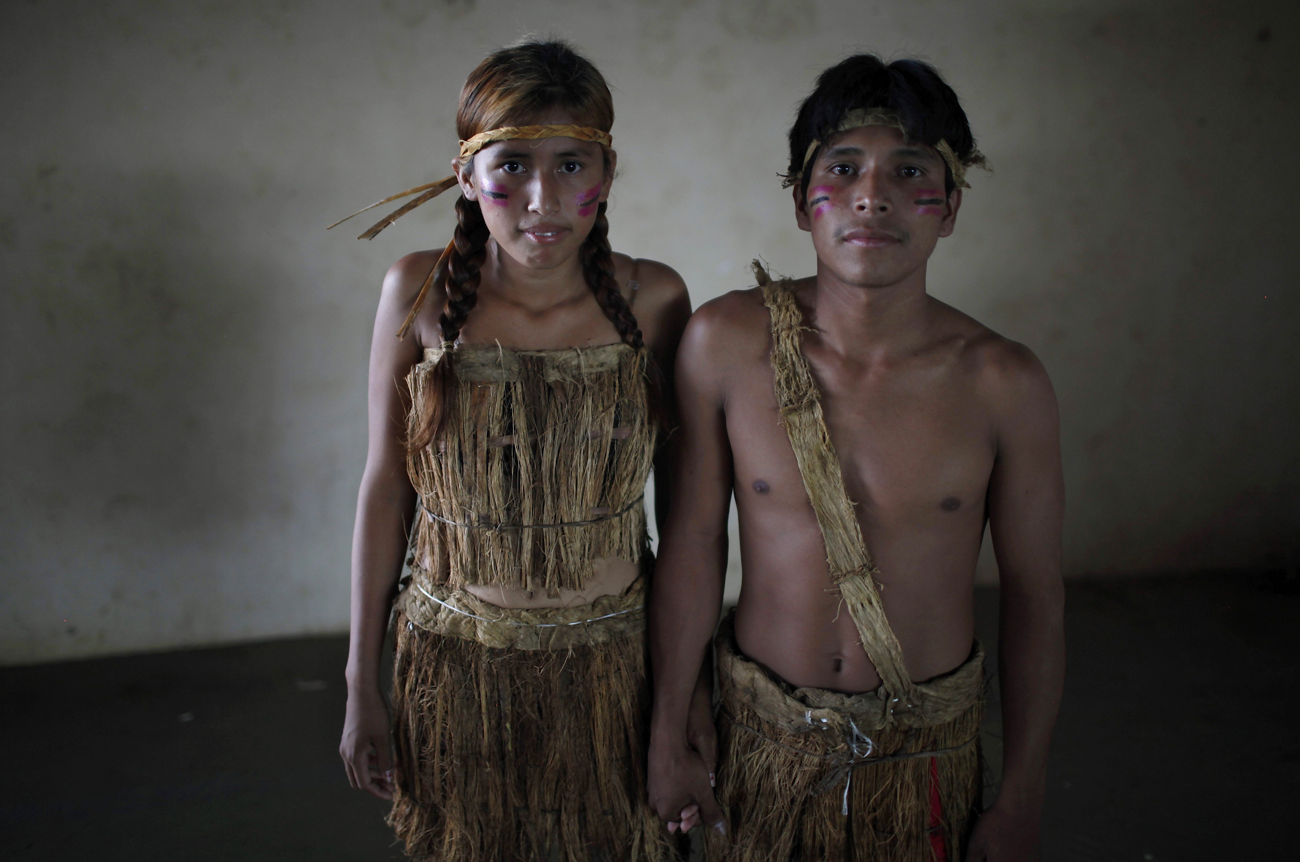 Erika Kanacmi, left, and Denis Capi, an Esse Ejja indigenous couple, pose for a portrait before a collective wedding ceremony in Cobija, Bolivia, Saturday, Oct. 6, 2012. Indigenous couples from Bolivia’s Amazon region got married in a mass wedding coined “Collective Marriage from our Identity 2012,” organized by the government. Many of the couples were already legally married, but wanted to attend a ceremony that included some indigenous traditions from the Amazon. (AP Photo/Juan Karita)