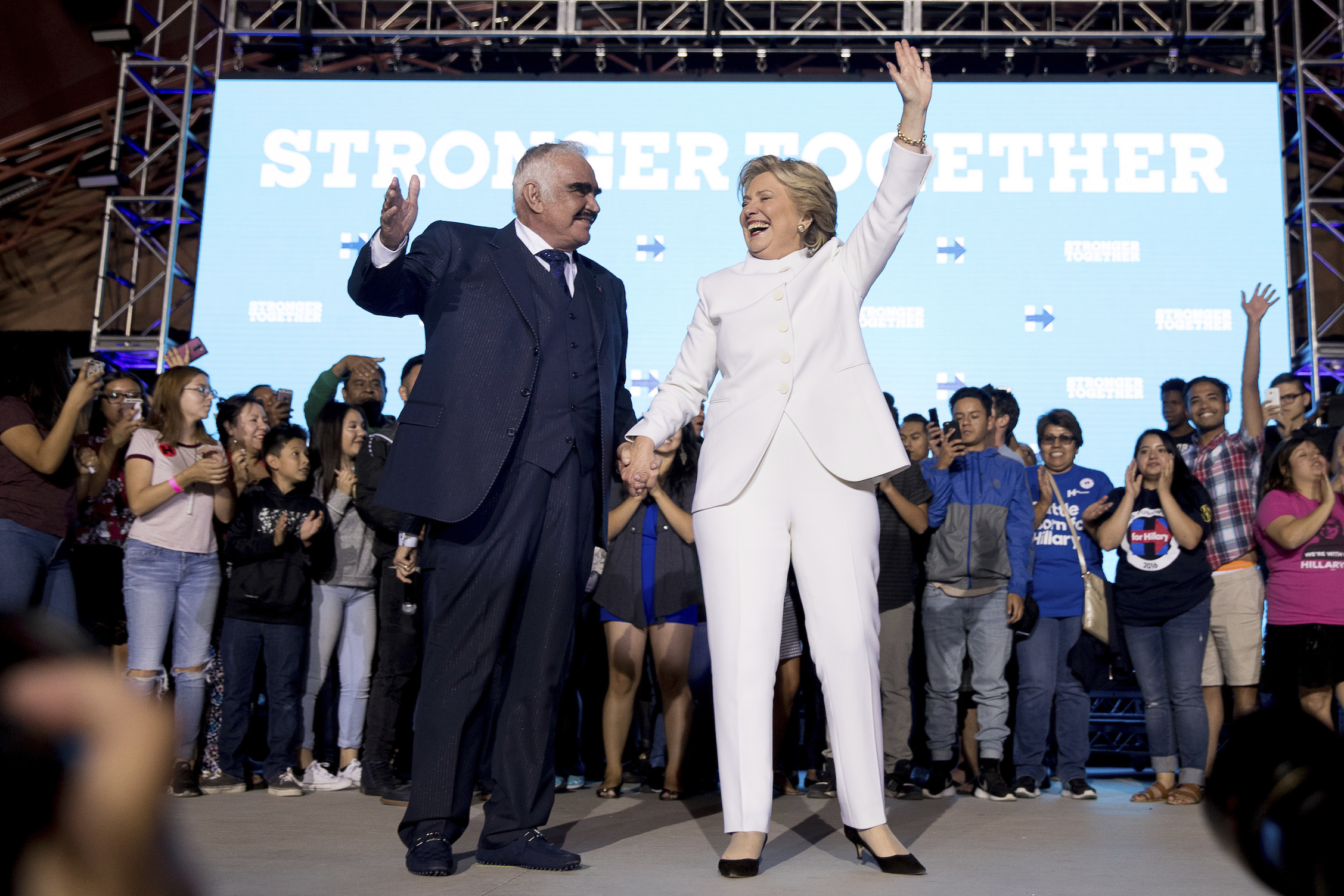 Democratic presidential candidate Hillary Clinton, right, and singer Vicente Fernandez, left, stand on stage together at debate watch party at the Craig Ranch Regional Amphitheater in North Las Vegas, Wednesday, Oct. 19, 2016, following the third presidential debate. (AP Photo/Andrew Harnik)